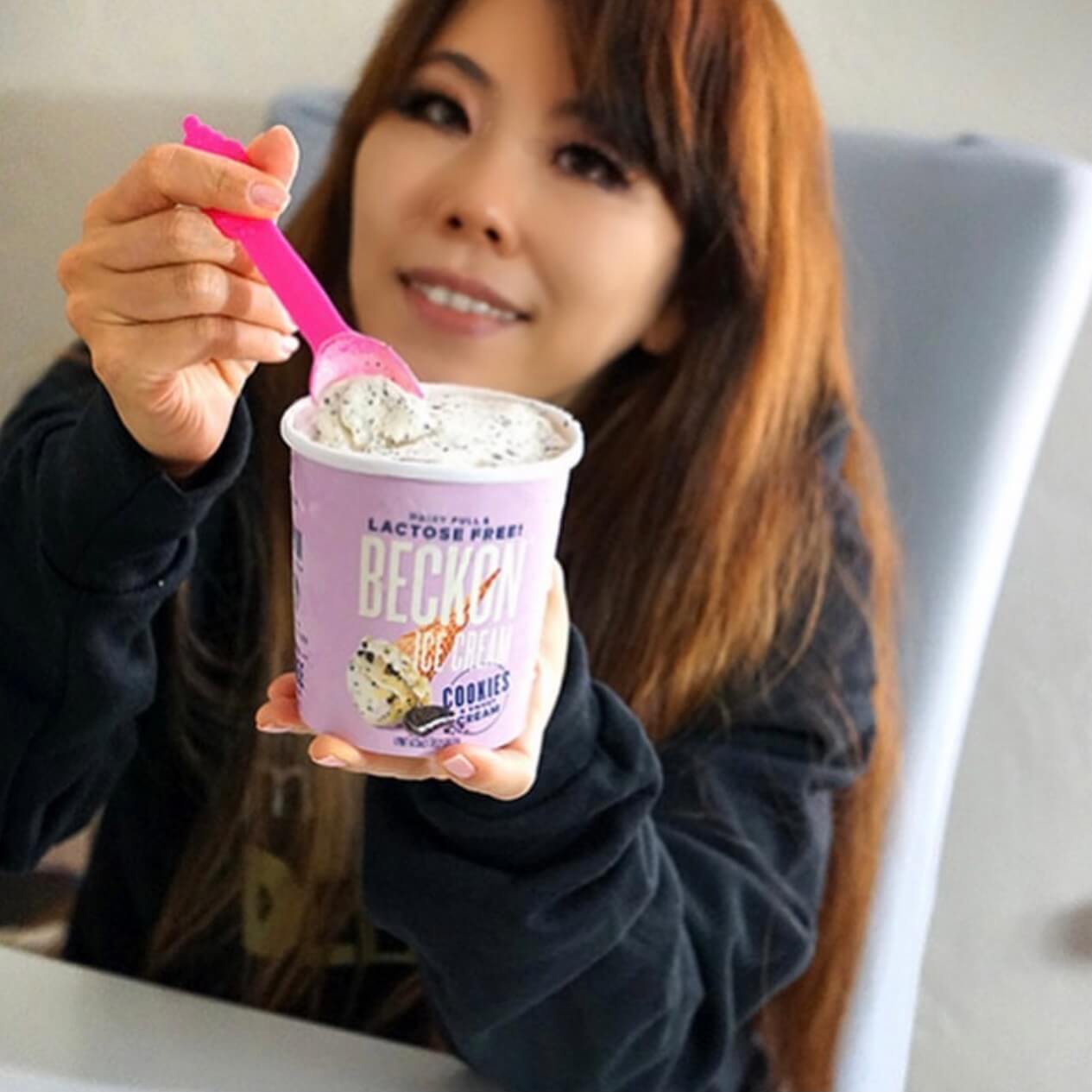 Woman holding a pint of ice cream and displaying it to the camera